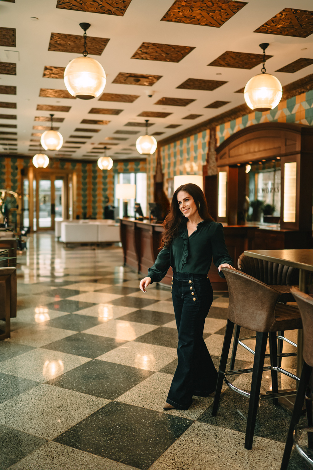 woman in forest green blouse in hotel lobby