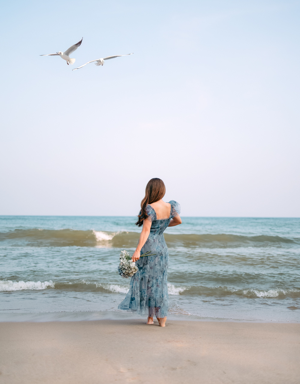 Woman in blue tulle dress on beach