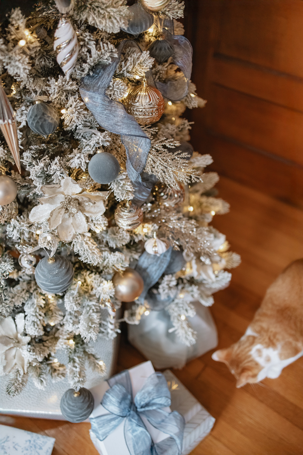 flocked christmas tree with blue and gold ornaments