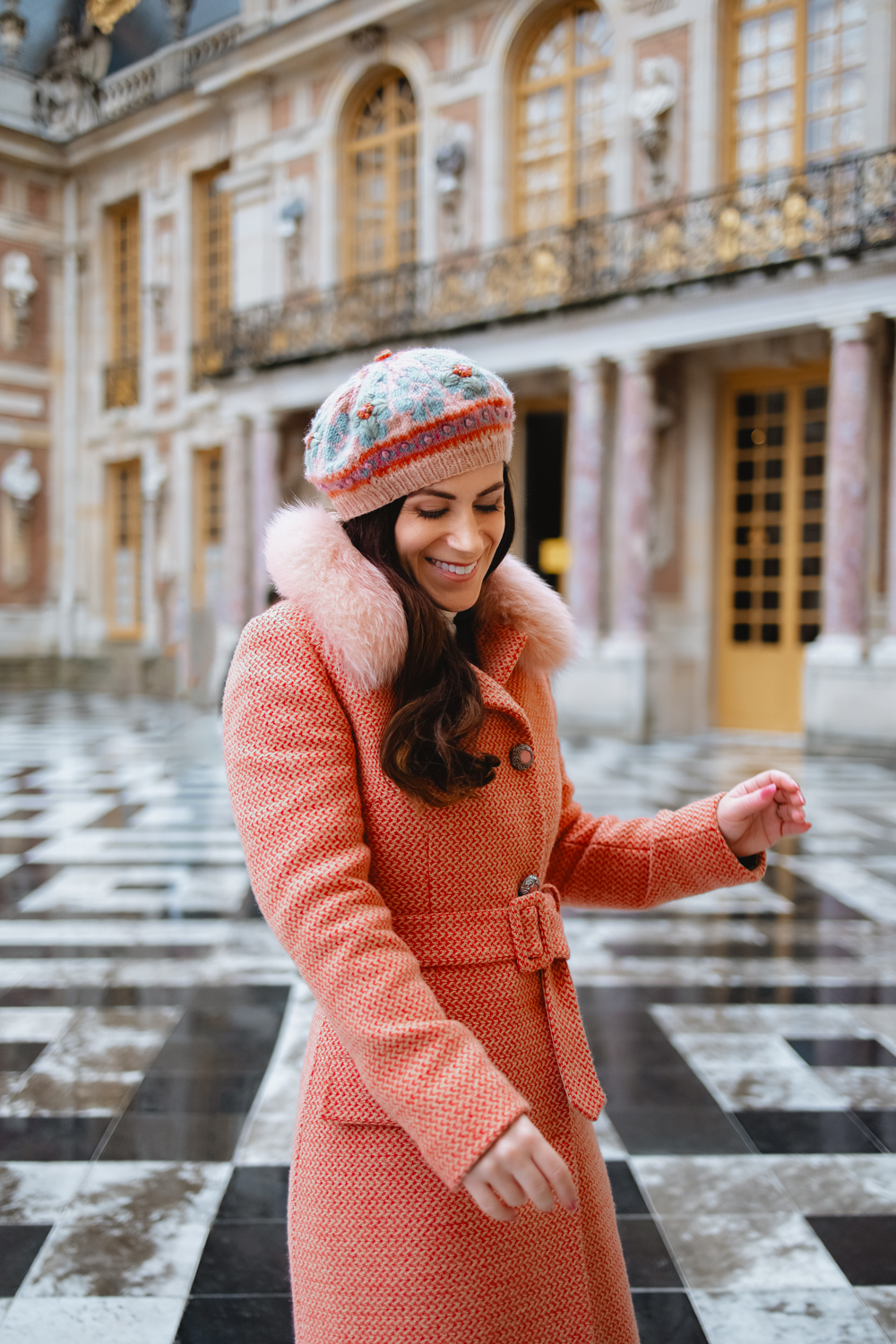 coral coat and matching beret at Versailles